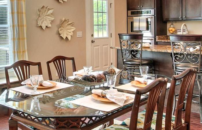 kitchen table with four chairs and place settings for dinner